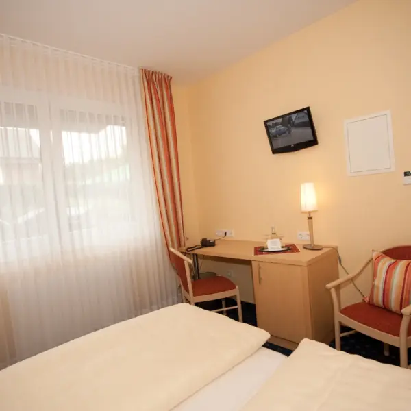 Bett und Schreibtisch des Doppelzimmer Superior im Gasthaus Hubertus Melle